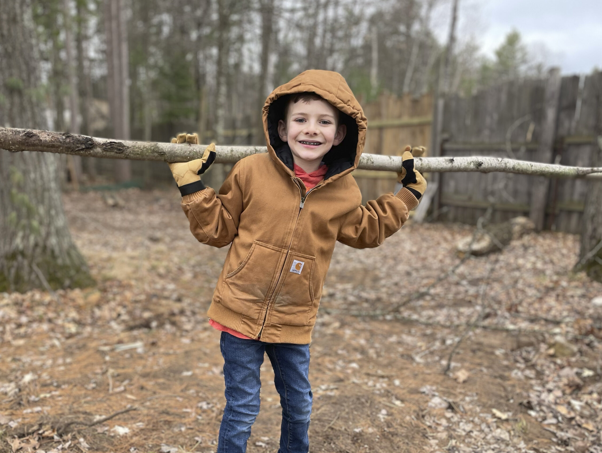 A young volunteer helping clear storm damage out of the fawn yard.