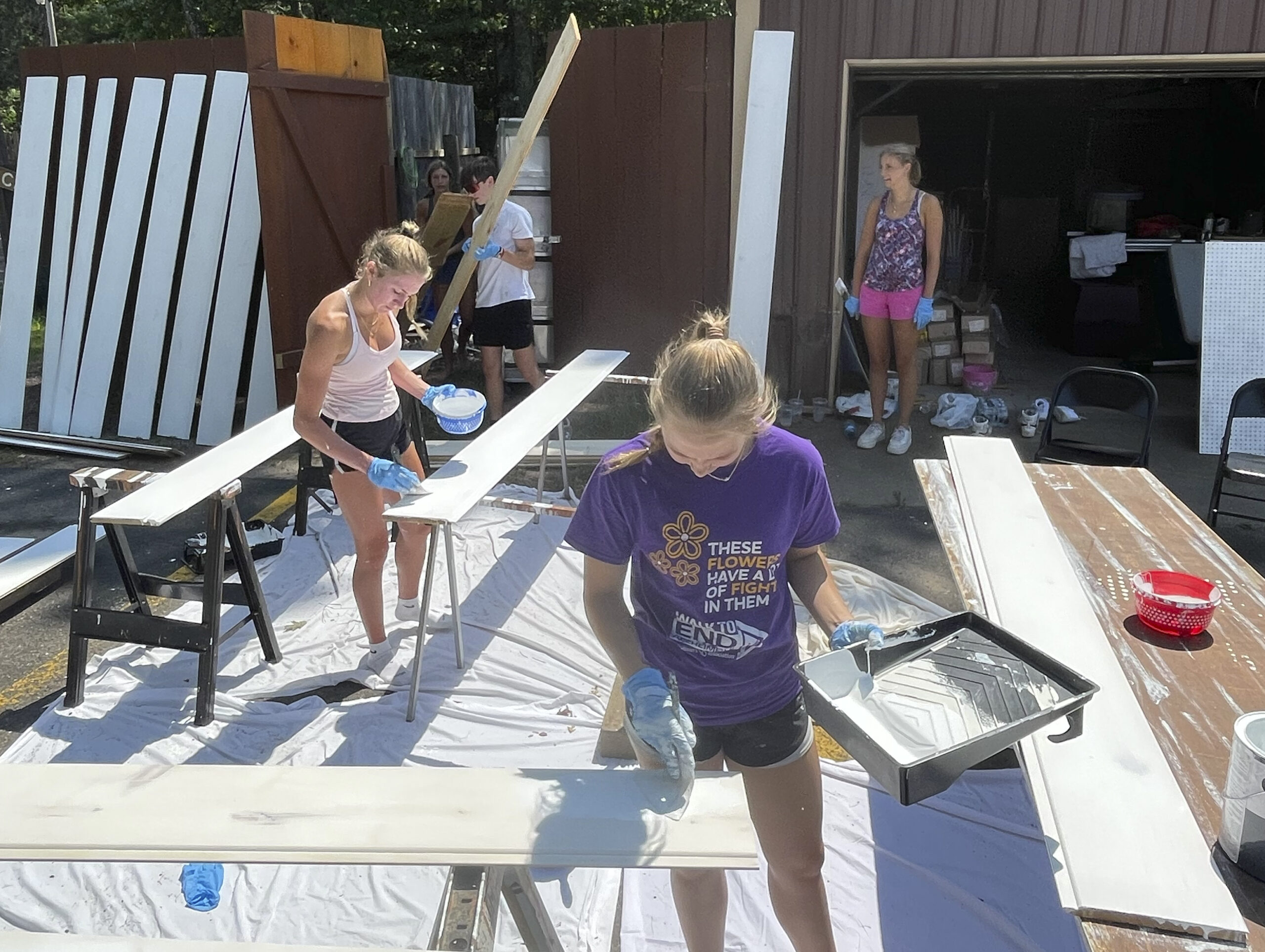 volunteers helping paint paneling.