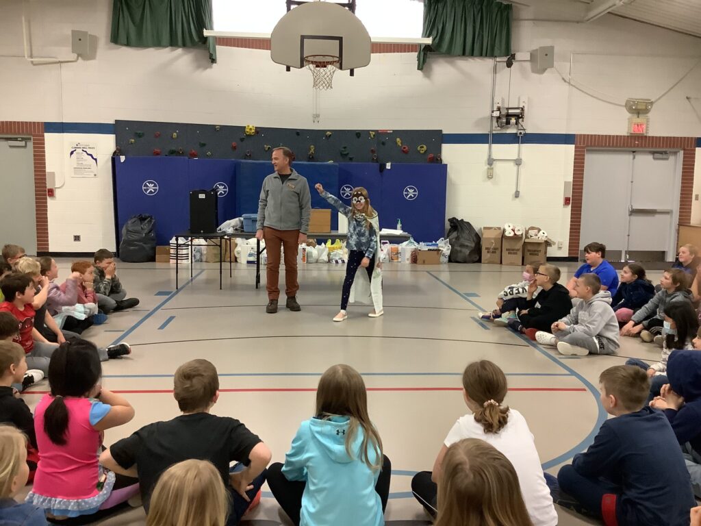 School kids in a gymnasium attending a wildlife education program.